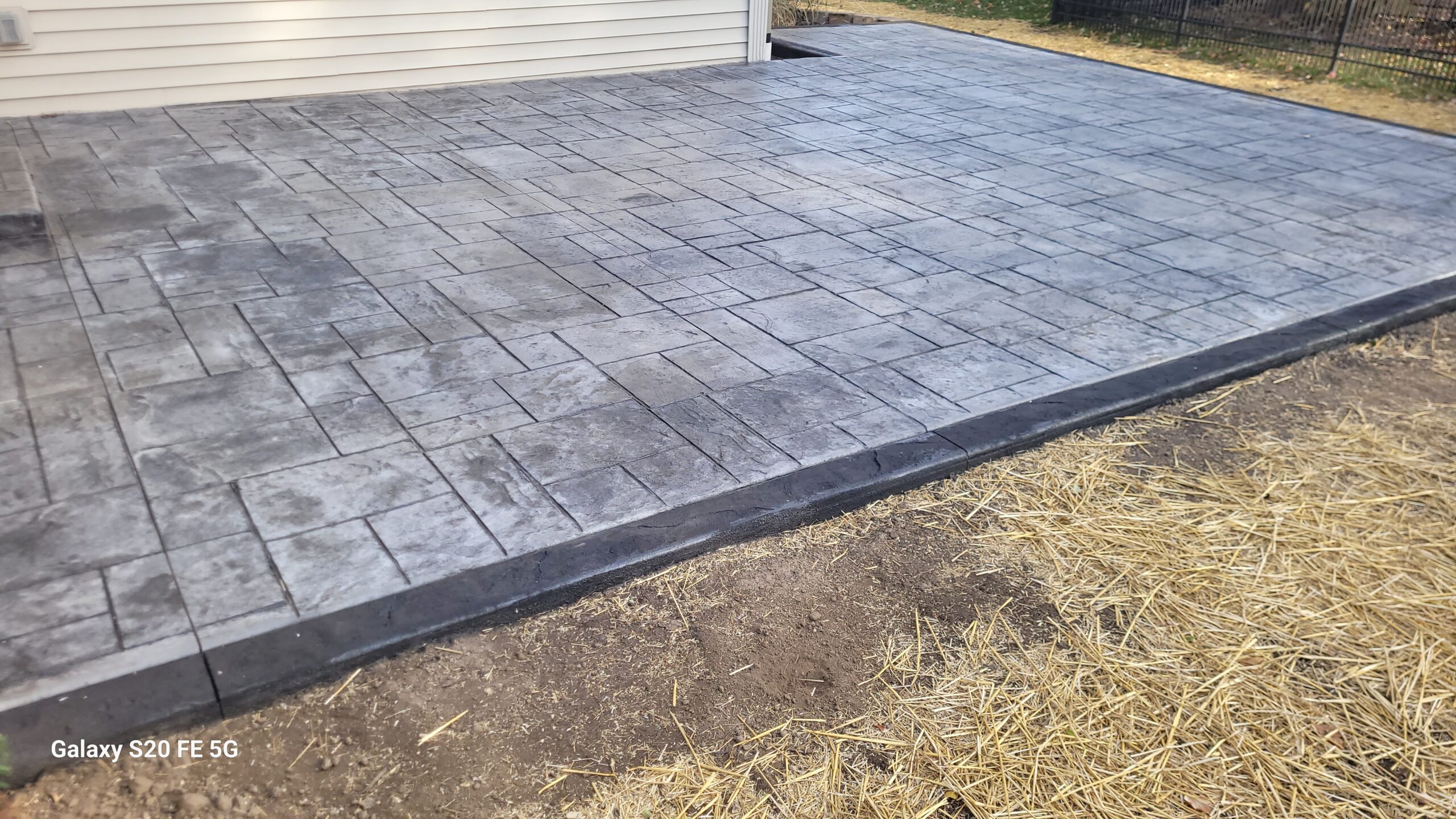 an ashlar slate grey patio with an onyx black heavy stone pattern border
